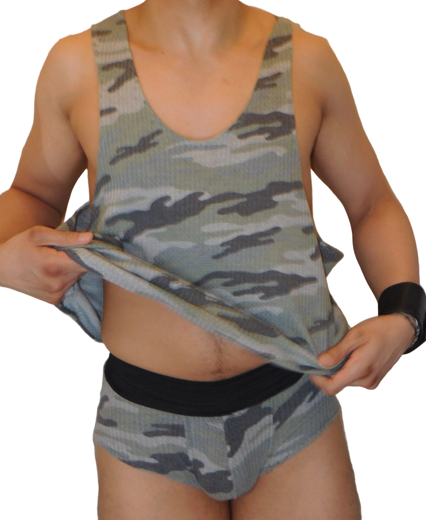 Person wearing a camouflage tank top and shorts with a white curtain background