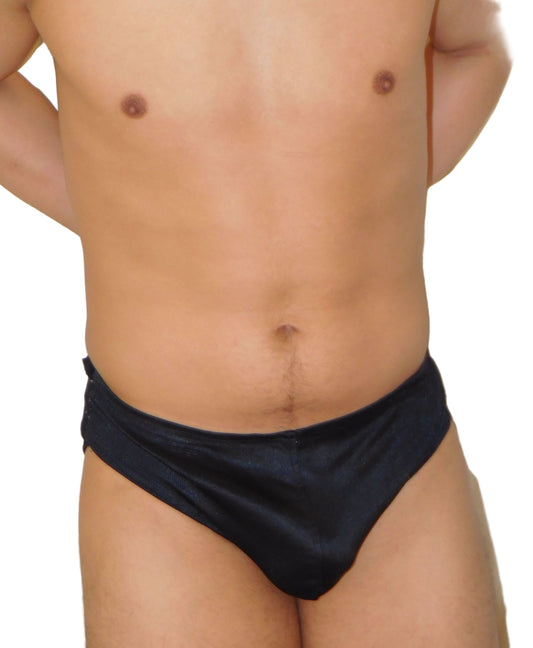 Man wearing black swim briefs against a white background