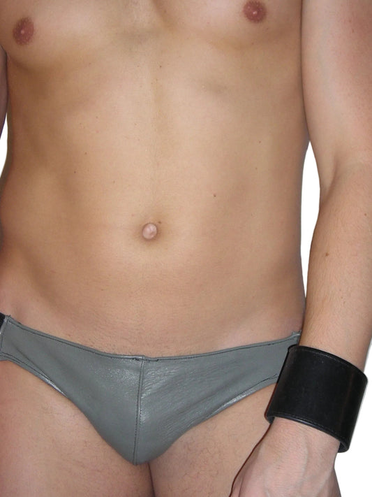 Partial view of a person wearing gray underwear with a black wristband on a white background